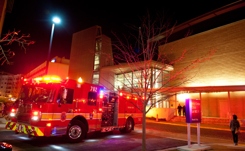 image of emergency vehicles at night outside building