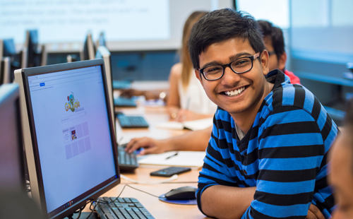 Student smiling while working at computer